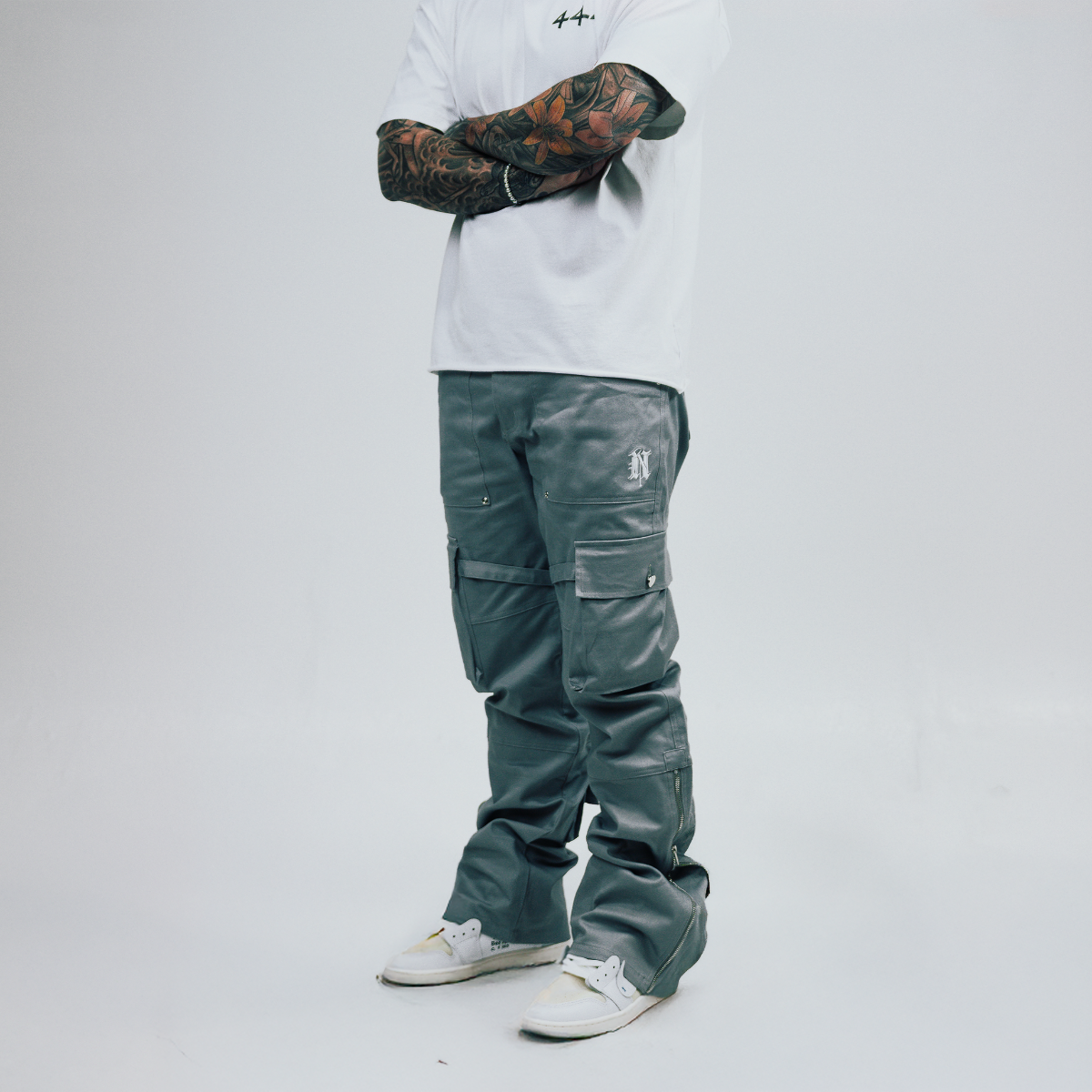 Person wearing a white hoodie and dark pants on a plain background